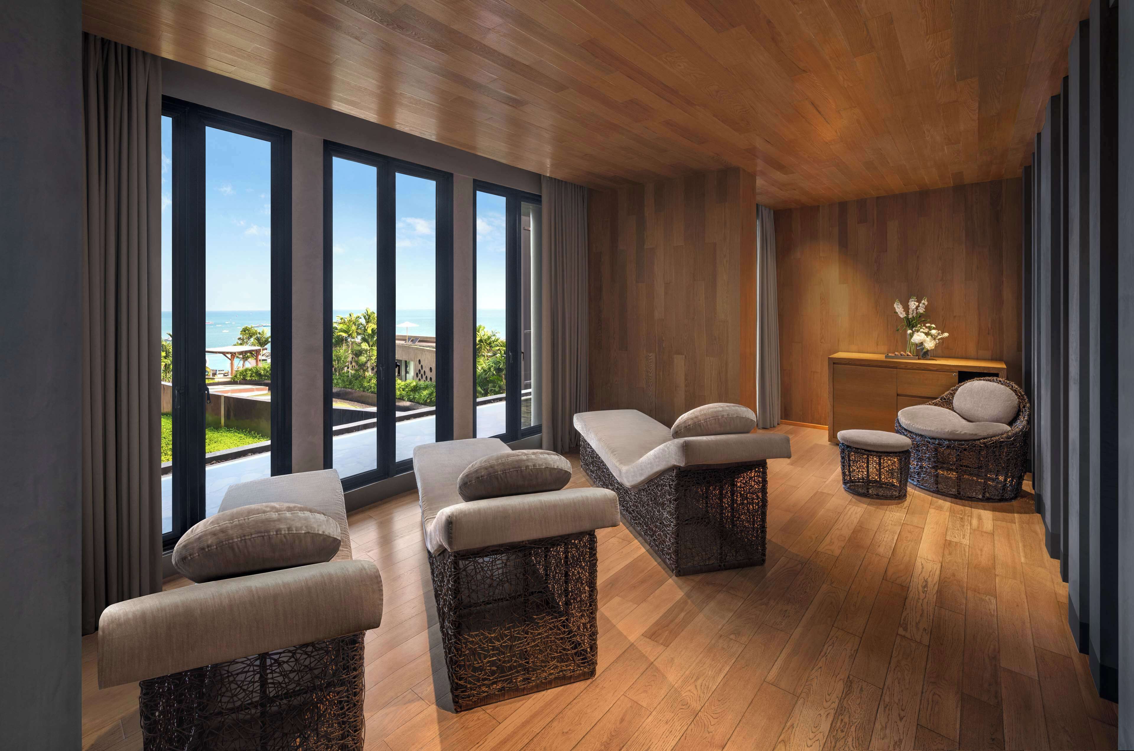 Una moderna spa con arredi in vimini, ampie finestre e vista sull'oceano.