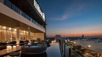 Un hôtel moderne doté d’un bar sur le toit offrant une vue sur le front de mer.