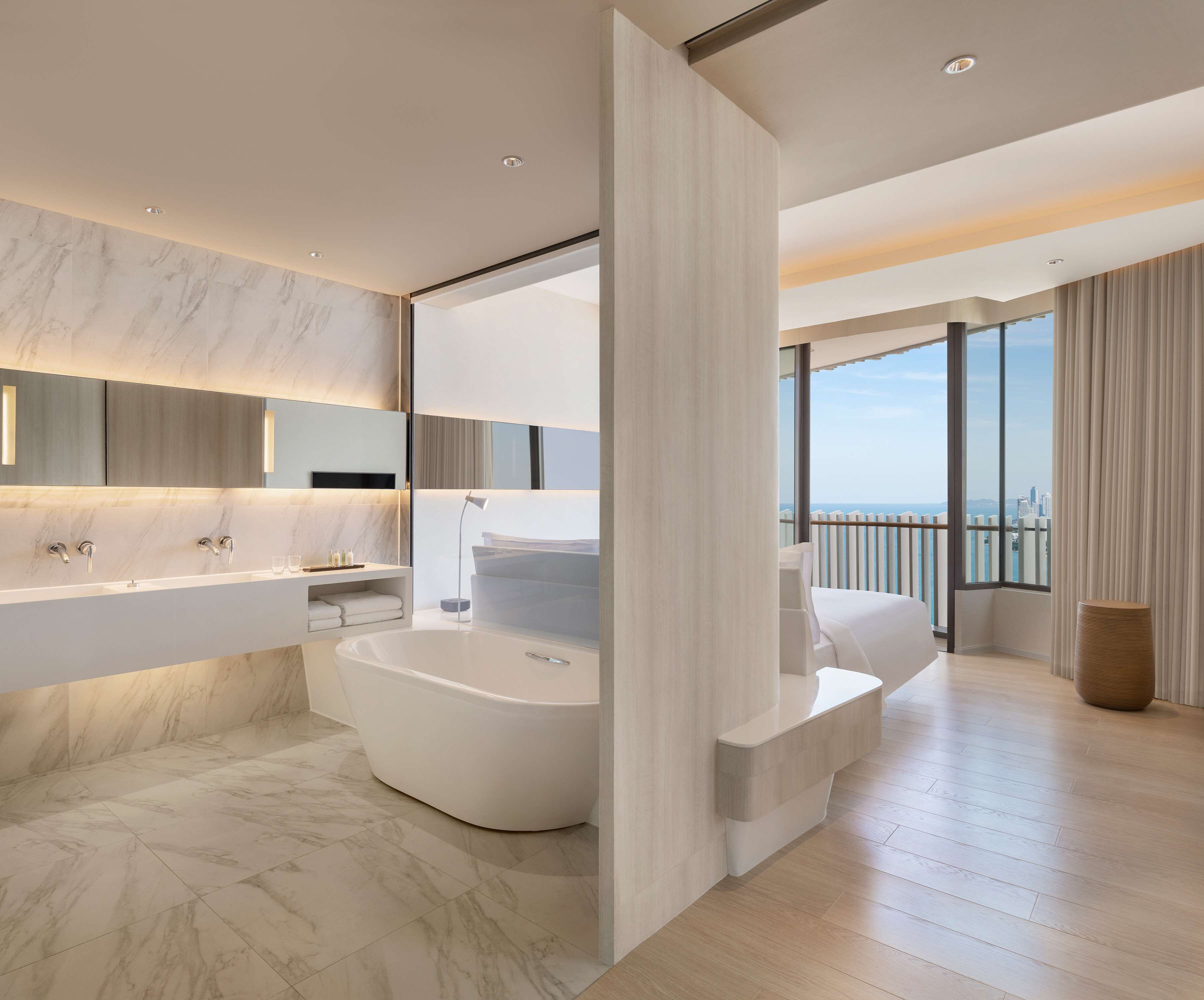 A modern bathroom with a large bathtub, a double sink, and a vanity.