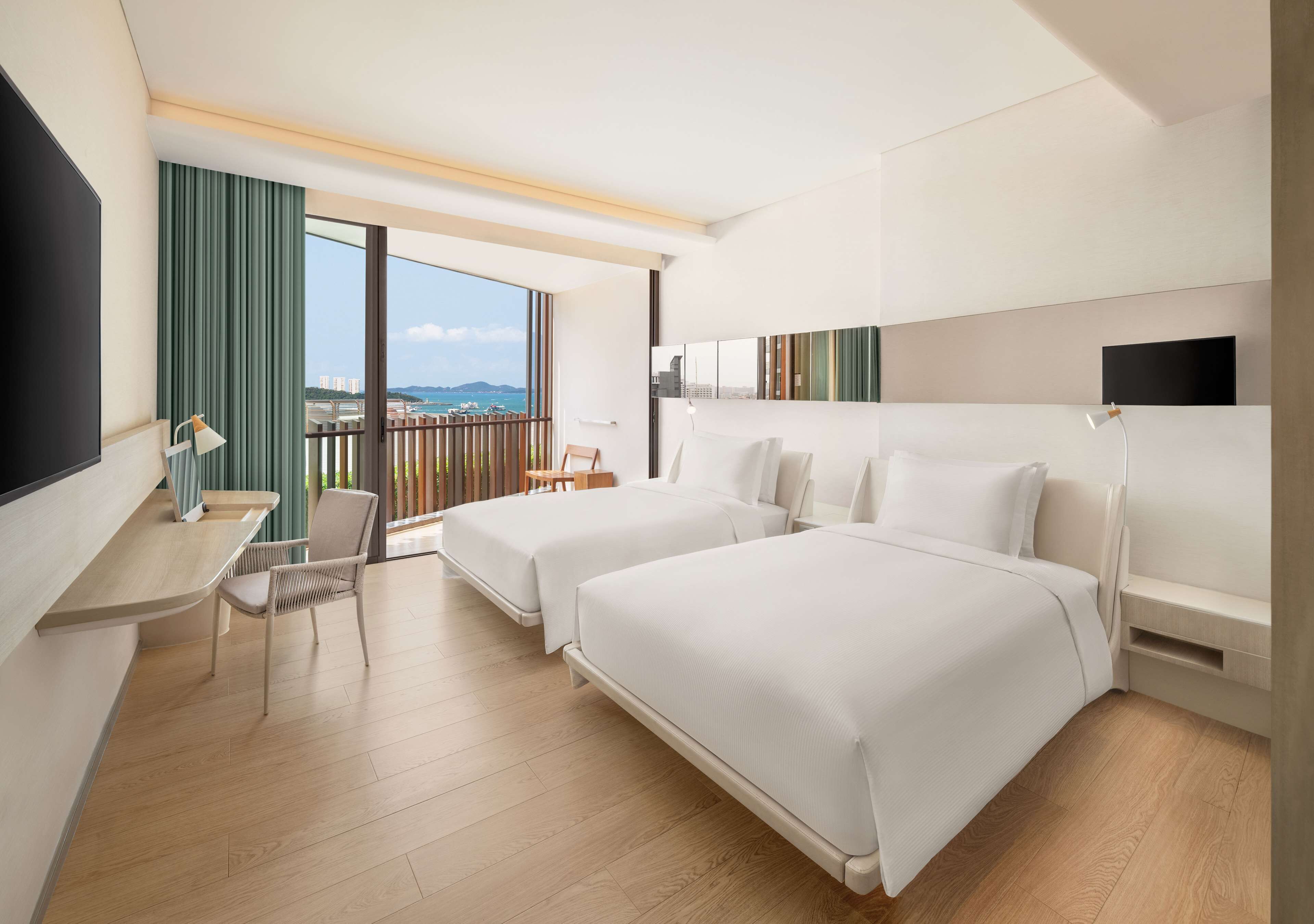 Habitación de hotel con dos camas, un escritorio, una silla y un televisor.