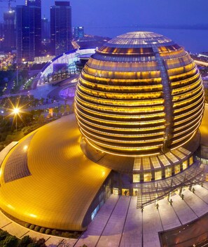 A modern, circular building with a unique, layered design. - InterContinental Hangzhou ICC by IHG (Hangzhou)