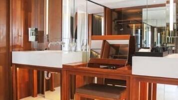 Un baño moderno con detalles de madera, un espejo grande y un tocador con lavabo.