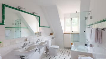 Un bagno moderno con due lavandini, un water e una cabina doccia in vetro.