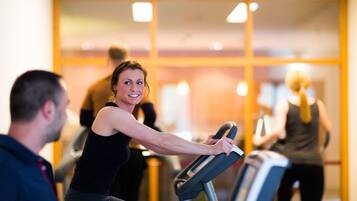 A gym with stationary bikes and a mirrored wall.