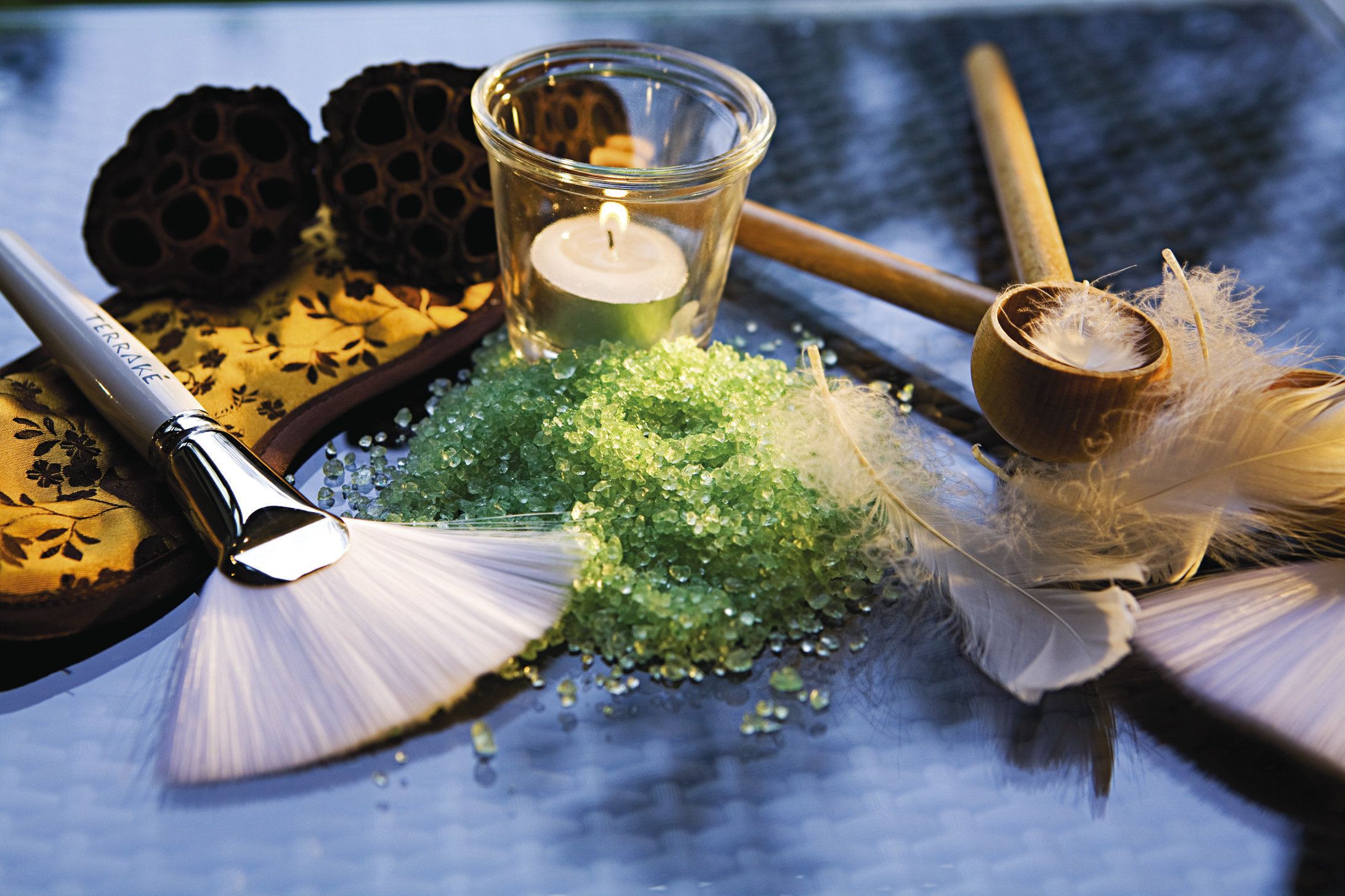 A table with a candle, a brush, and decorative items.