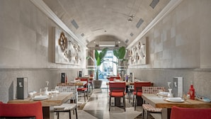 A spacious dining area with high ceilings, modern decor, and a view of the street. - NH Collection Palacio de Tepa (Madrid)