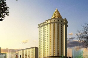 A high-rise building with a distinctive dome on top, featuring a grid of windows and a central entrance. - Jinding Hotel (Wenzhou)