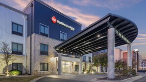 A Best Western PLUS hotel with a modern design, featuring a covered entrance and a landscaped outdoor area. - Best Western Plus Austin Airport Inn & Suites (Austin)