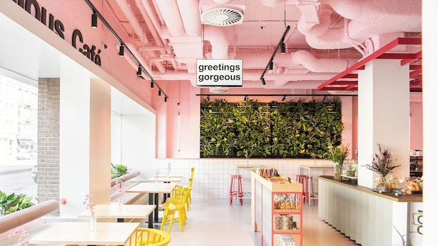 A modern cafe with yellow chairs, a green wall, and a pink ceiling. - Conscious Hotel Vondelpark (Amsterdam)