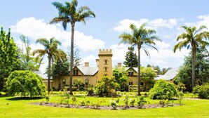 A large, yellow building with a tower, surrounded by lush greenery and palm trees. - Seahorse Inn Hotel & Villas (Boydtown)