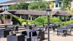 Un espace extérieur aménagé avec des meubles en osier et un lampadaire.