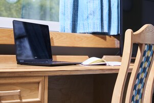Un escritorio de madera con una computadora portátil y una libreta abierta.