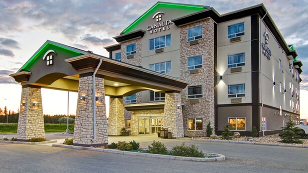 A hotel with a modern design, featuring a prominent entrance with a covered walkway and stone pillars. - Tisdale Canalta Hotel (Tisdale)