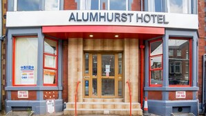 The exterior of the Alumhurst Hotel with a prominent entrance, a sign indicating a private car park, and a clear view of the building's facade. - Alumhurst Hotel (Blackpool)