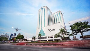 Un hotel alto con un llamativo letrero que dice "Crystal Crown", arquitectura moderna y cielo despejado.