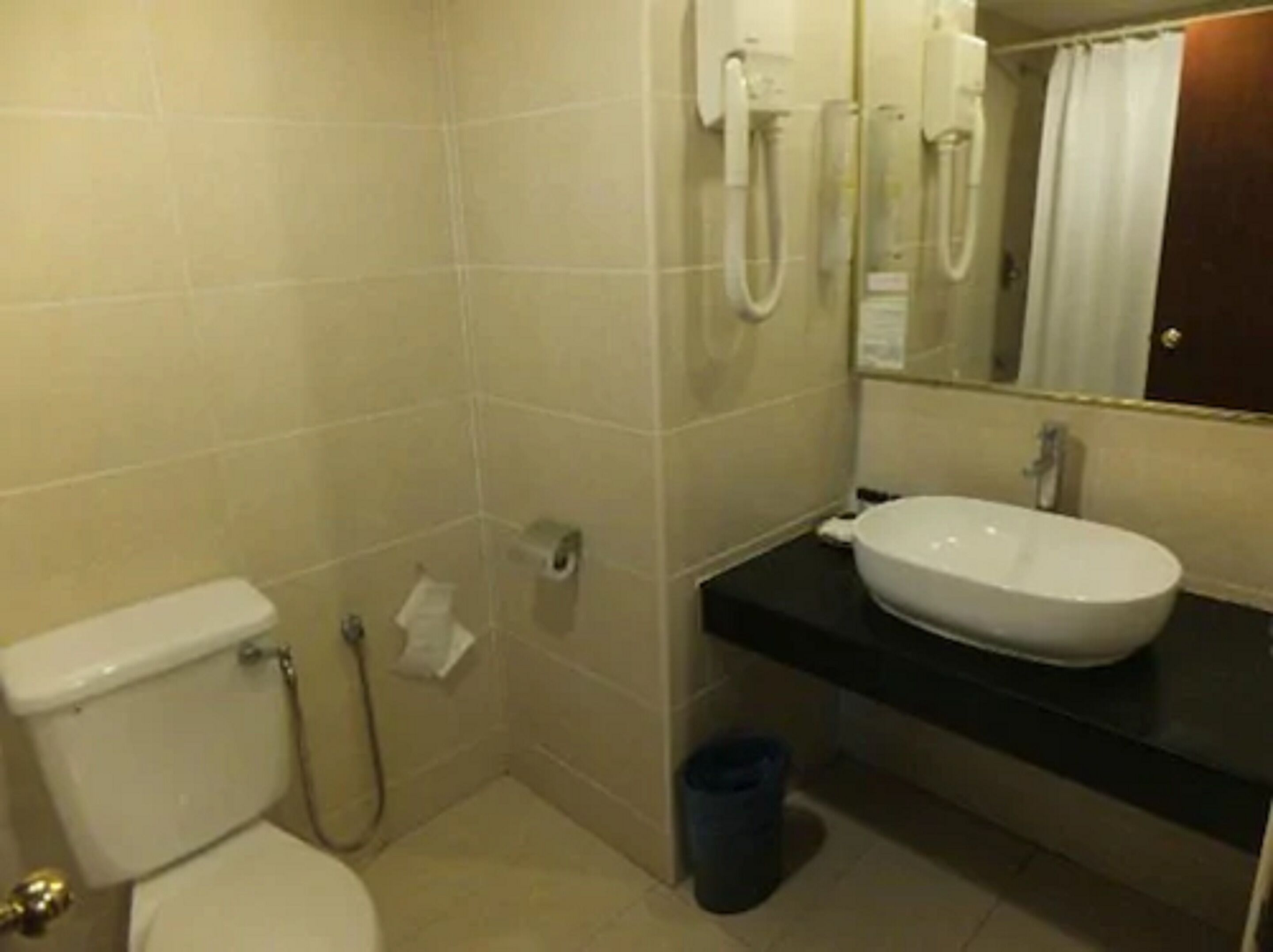 A small bathroom with a toilet, a sink, and a mirror.