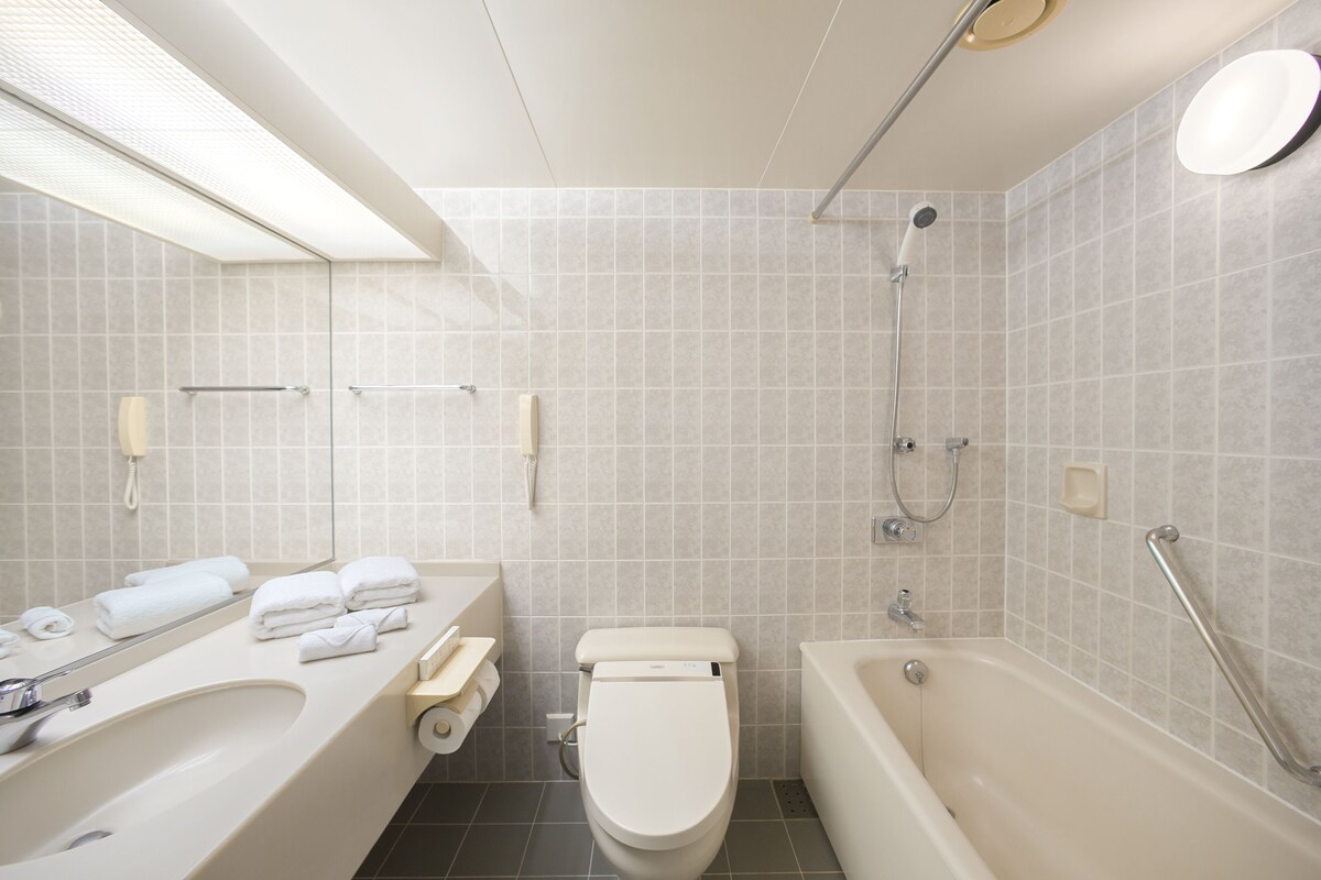 A modern bathroom with a bathtub, toilet, and sink.
