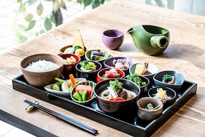 A variety of Japanese dishes arranged on a tray, including rice, vegetables, and meat, with chopsticks and small bowls. - Grand Mercure Sapporo Odori Park (Sapporo)