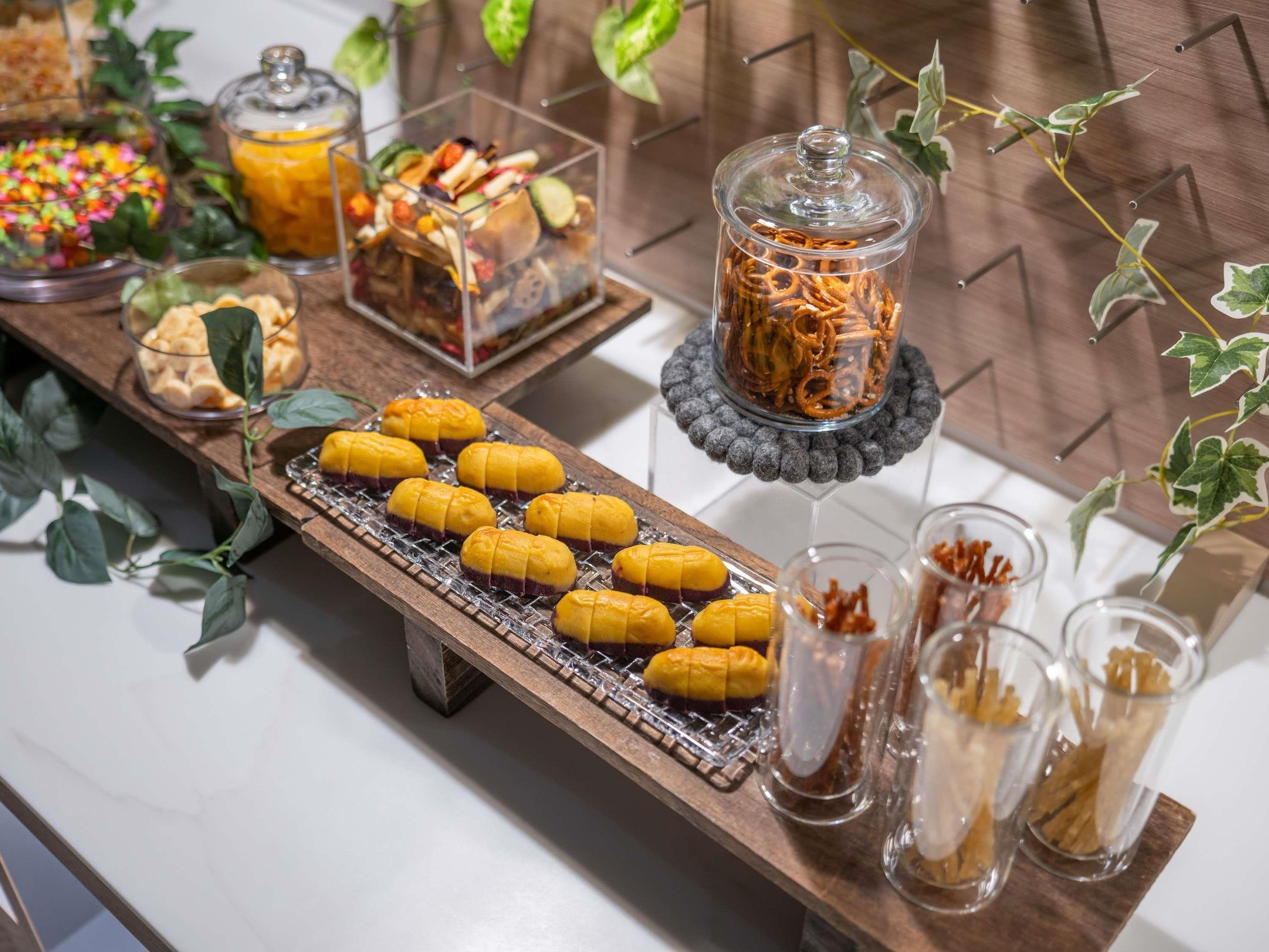 A buffet table with various food items and condiments.