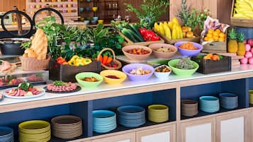 Un bufé con diversos alimentos y una variedad de recipientes y platos.