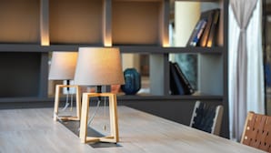 A wooden table with two lamps, a bookshelf, and a chair in a room with a modern design. - ANA Holiday Inn Kobe Sanda by IHG (Sanda)
