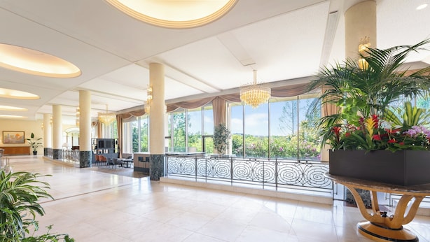 A spacious lobby with a reception desk, seating area, and large windows offering a view of greenery. - ANA Holiday Inn Kobe Sanda by IHG (Sanda)