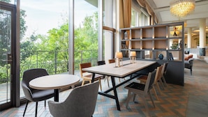 A spacious room with a large table and chairs, a bookshelf, and a view of greenery outside. - ANA Holiday Inn Kobe Sanda by IHG (Sanda)