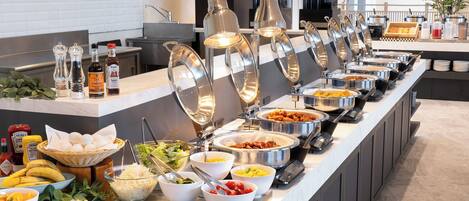 A buffet with various food items and condiments.