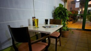 A table with two chairs, a menu, and two glasses of beer. - Bungalows Castillo Playa (Antigua)