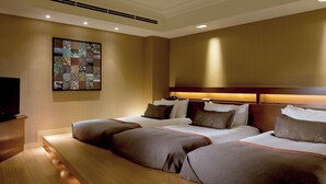 A hotel room with a large bed, a bedside table, and a wall-mounted TV. - Shima Kanko Hotel The Bay Suites (Shima)