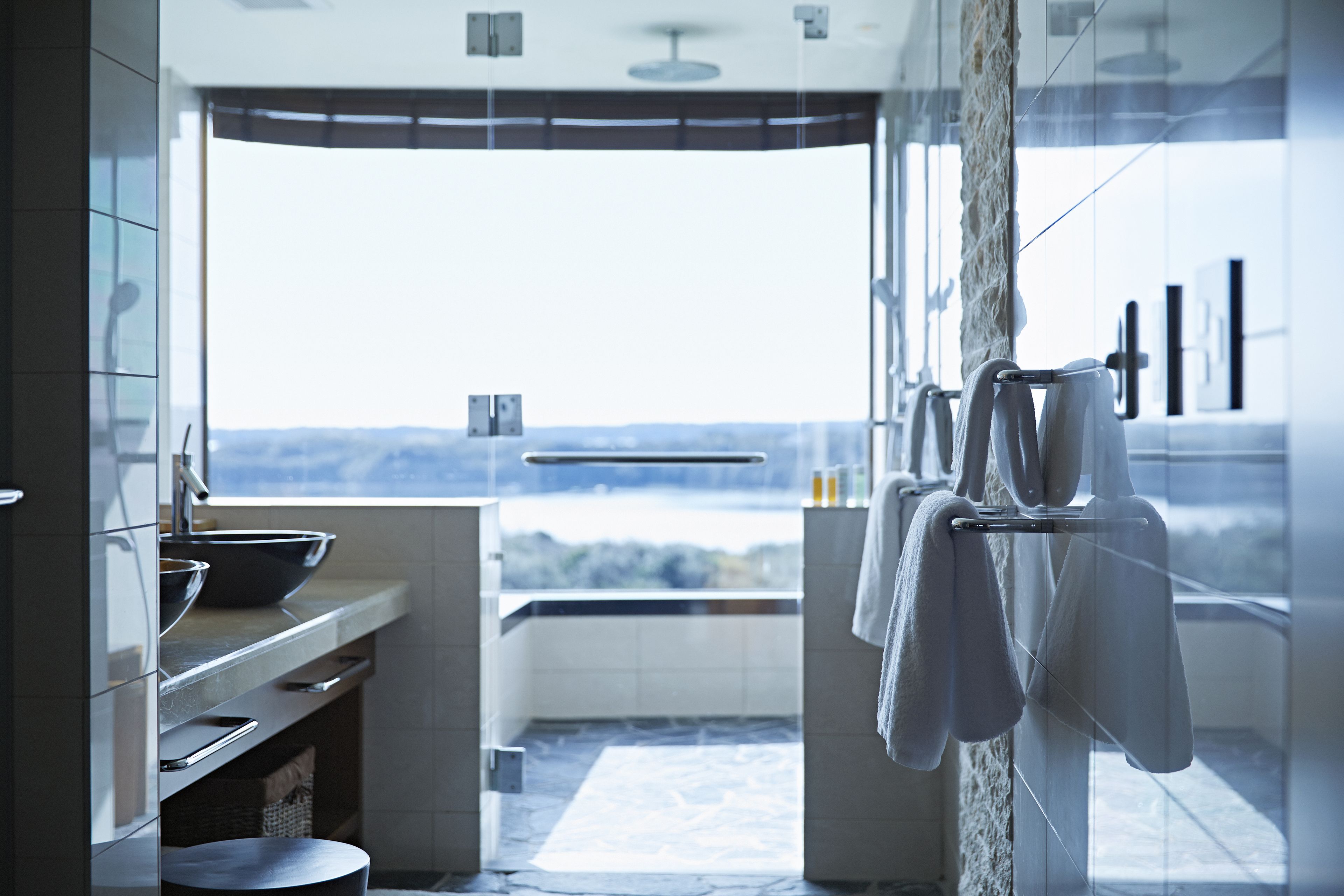 Ein modernes Badezimmer mit einem großen Fenster, einer Badewanne und einem Waschbecken.