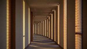 A long, narrow hallway with a series of windows on one side, allowing natural light to enter. - Shima Kanko Hotel The Bay Suites (Shima)