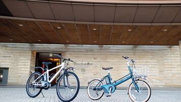 Two bicycles parked in front of a building with a brick facade and a sign that reads "The Bay Suites."