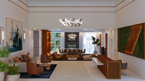 A modern interior with a central seating area, a reception desk, and a large abstract painting on the wall. - DoubleTree by Hilton Houston Westchase (Houston)