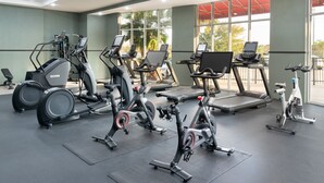 A gym with various cardio machines, including treadmills and elliptical trainers, arranged on a spacious floor with large windows providing natural light. - DoubleTree by Hilton Houston Westchase (Houston)