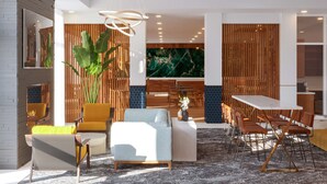 A modern hotel lobby with a dining area, seating arrangements, and a large wall-mounted artwork. - DoubleTree by Hilton Houston Westchase (Houston)