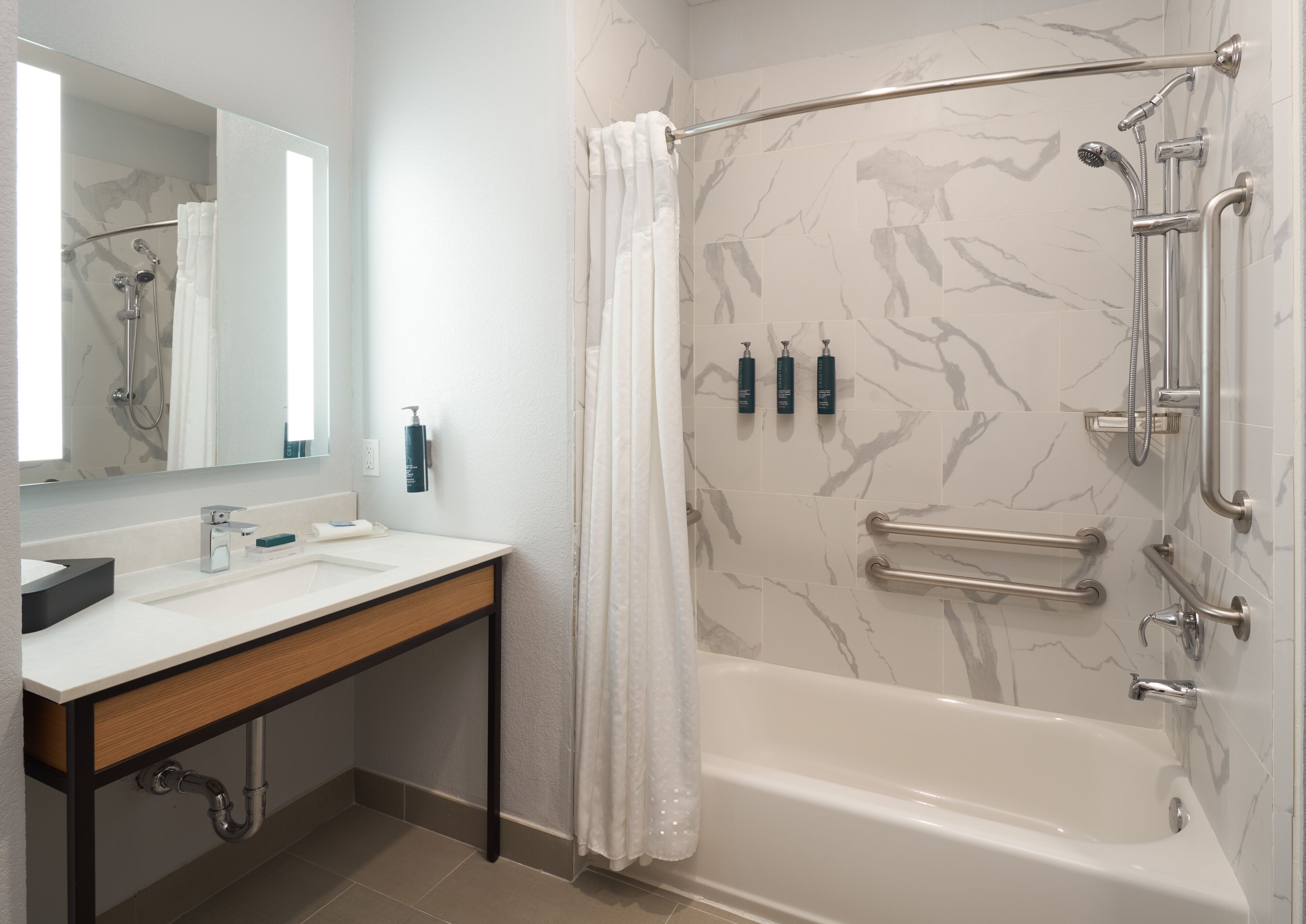 A modern bathroom with a bathtub, shower, and vanity.