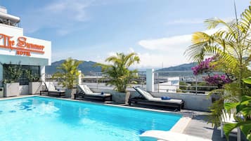 Outdoor pool, a rooftop pool, pool umbrellas, pool loungers