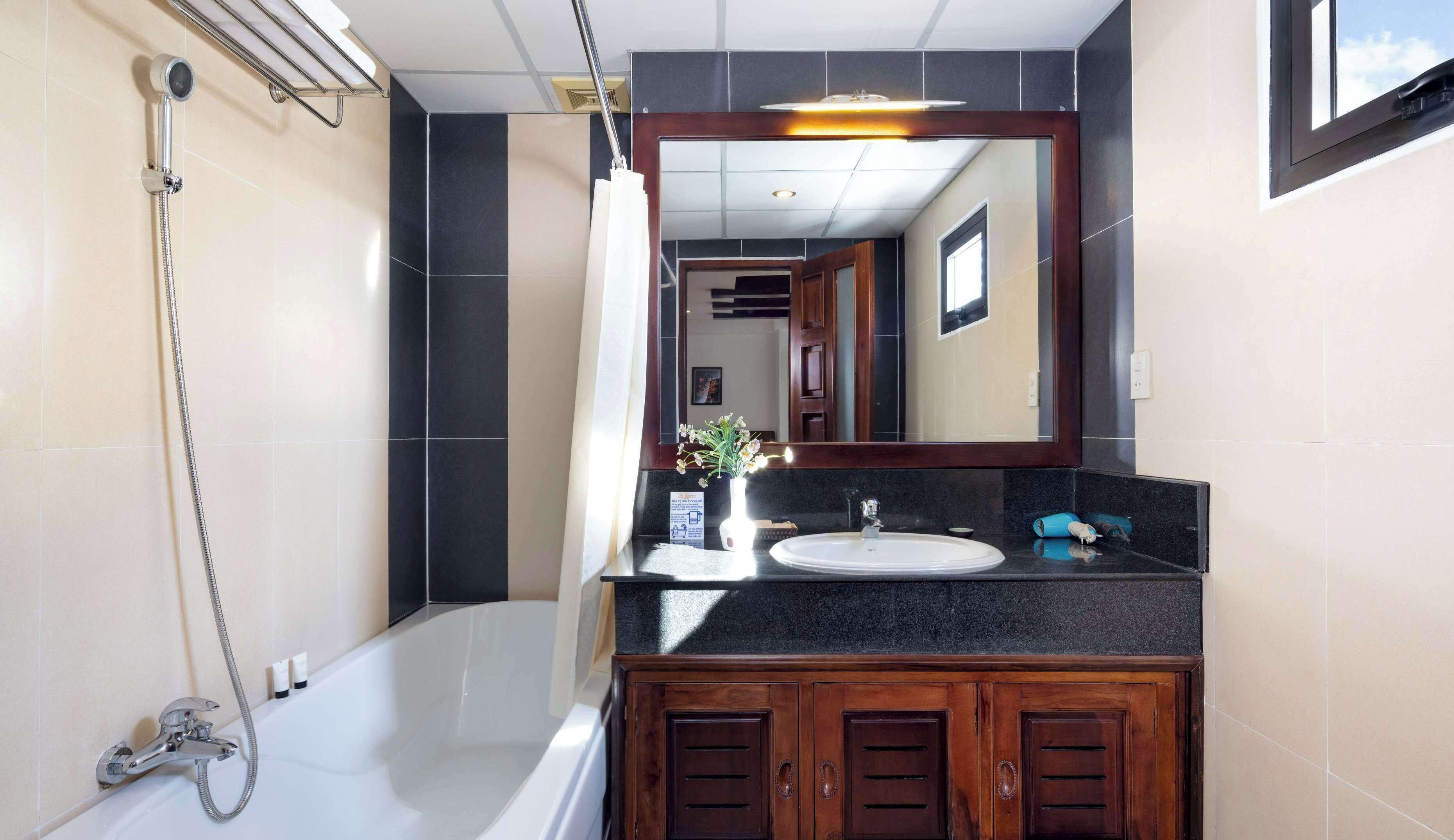 Un baño moderno con bañera, ducha, lavabo y tocador con armarios.