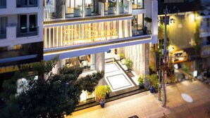 Un hotel de varios pisos con balcones, una entrada bien iluminada y un diseño arquitectónico moderno.