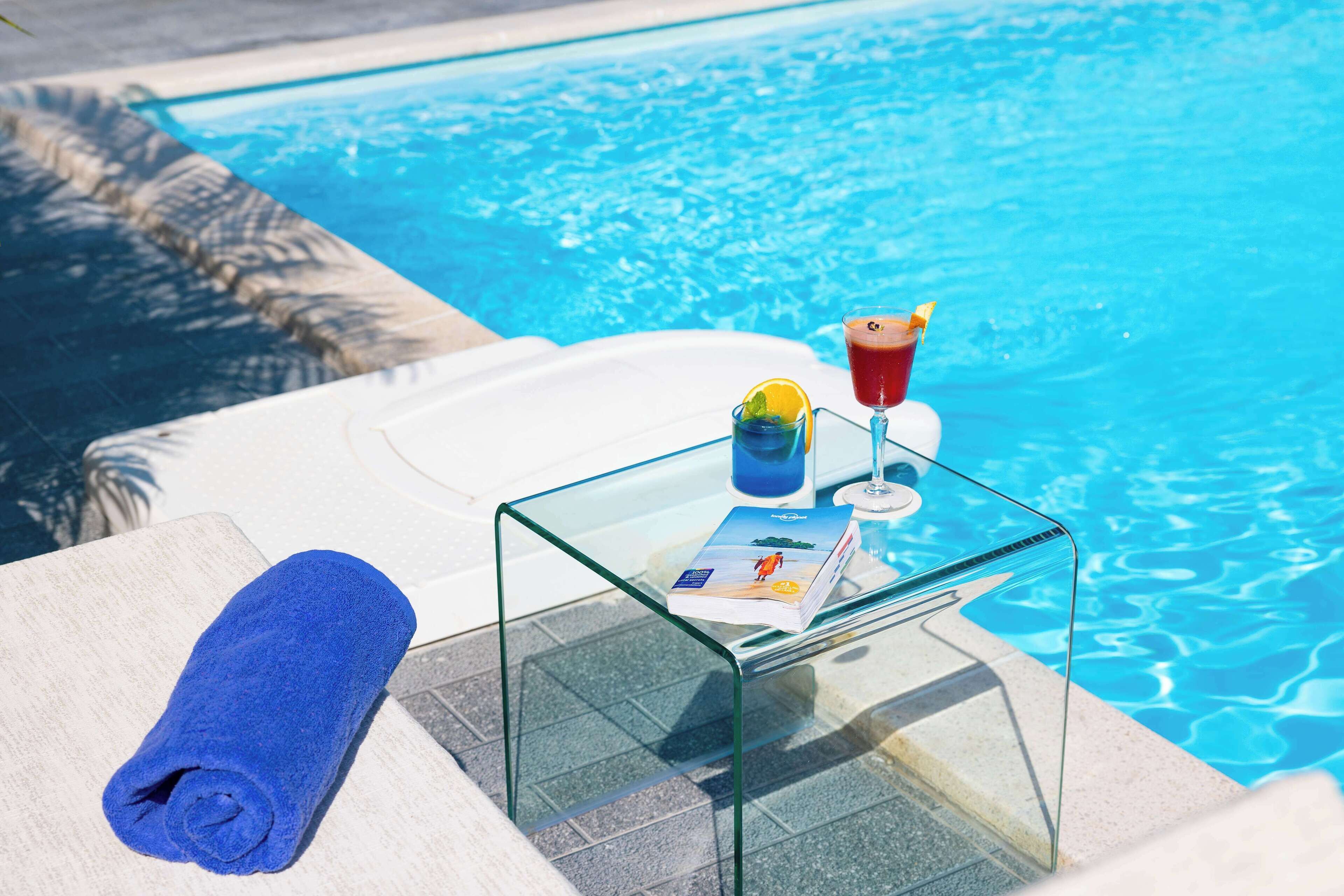 Una piscina al aire libre, una piscina en la azotea, sombrillas