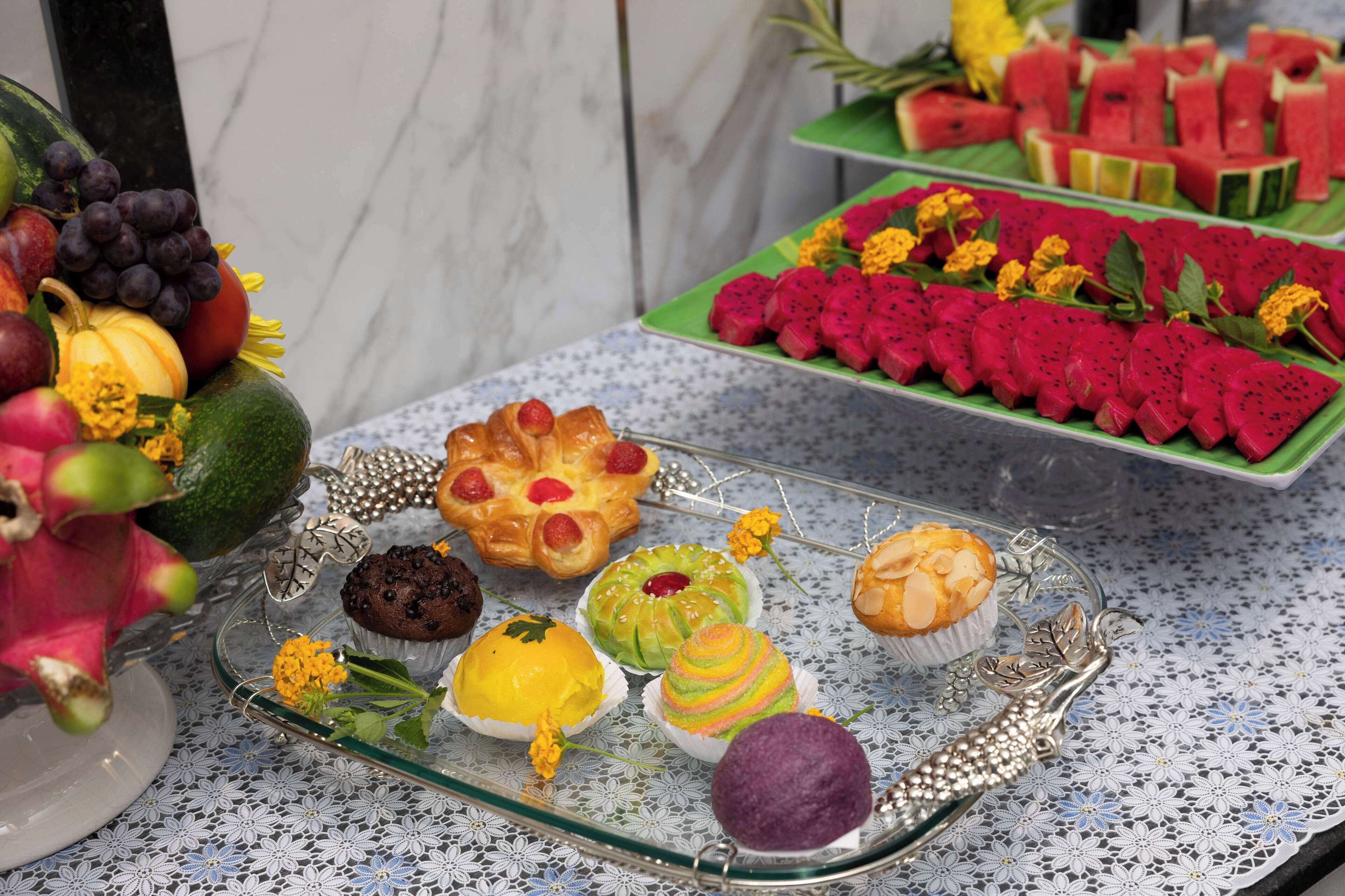 A table with various food items including fruits, pastries, and desserts.