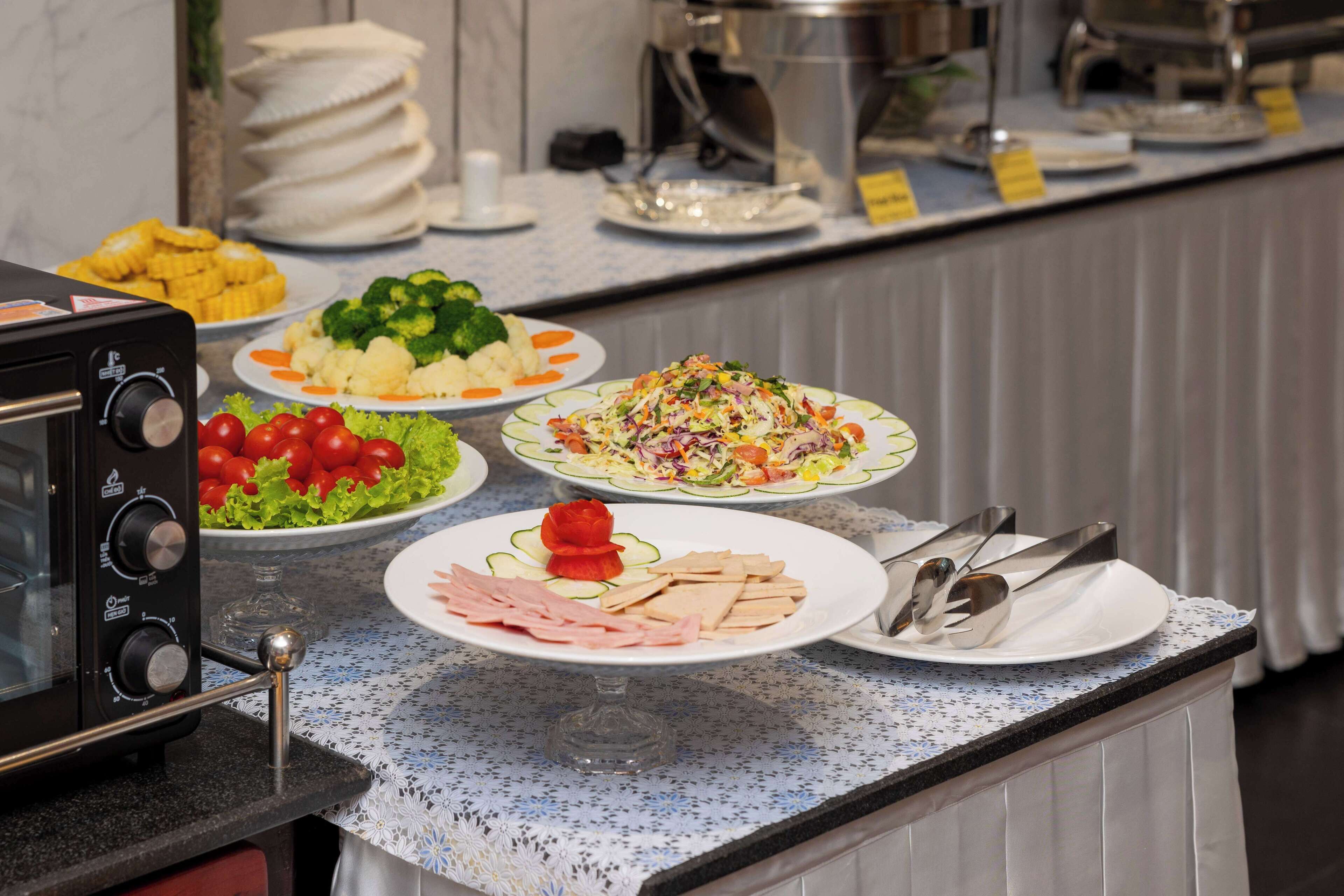 A buffet setup with various dishes including salads, vegetables, and meats.