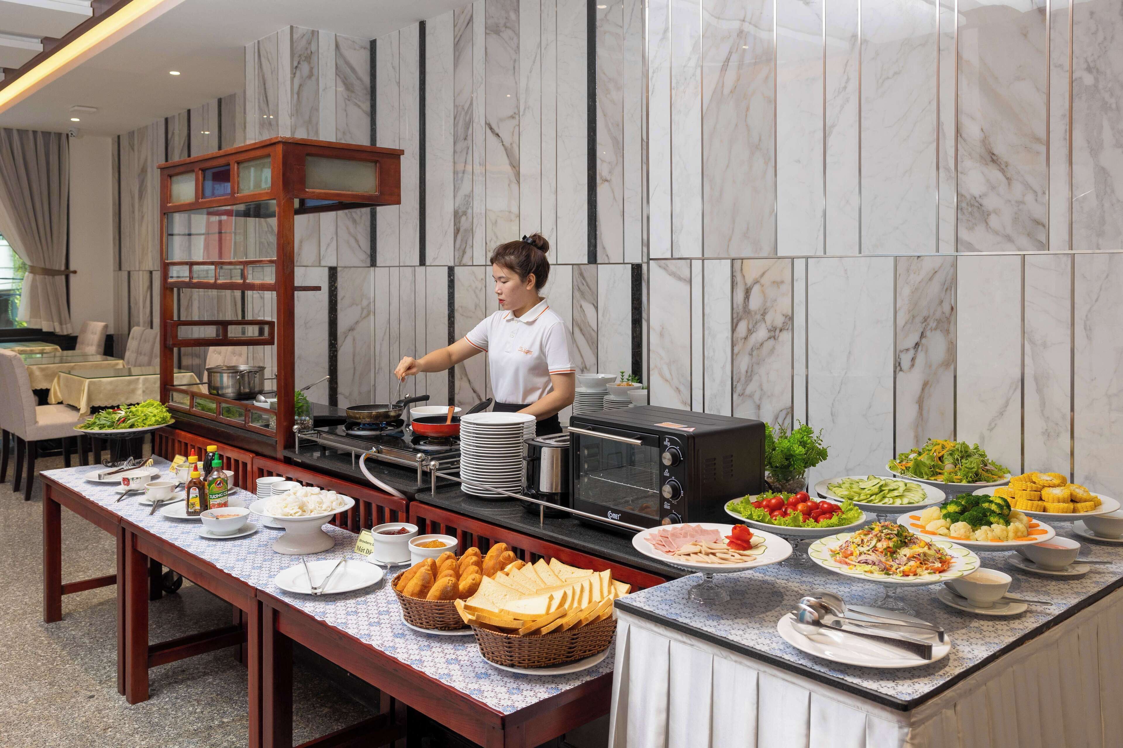 A buffet setup with various food items and a chef preparing food.