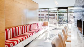 Eine moderne Hotelhalle mit einer Marmorbank, einer Sitzgelegenheit und einem großen Fenster mit Blick ins Freie.