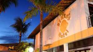 A building with a large sign reading "Hotel de los Héroes" and a palm tree in the foreground. - Benko's Praia Hotel (Porto Seguro)