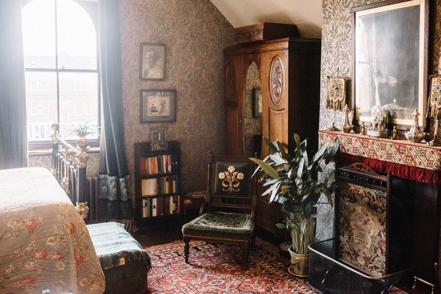 A traditional room with a bed, a wooden cabinet, a bookshelf, a chair, a large window, and a mirror.