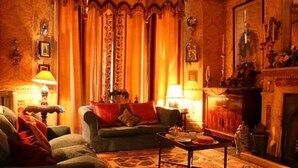 A warmly lit living room with a sofa, a coffee table, and a fireplace.