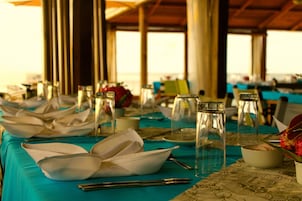 A table set for a meal with a blue tablecloth, clear glassware, and white dishes.