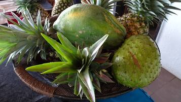 A fruit basket containing various fruits and a decorative plant.